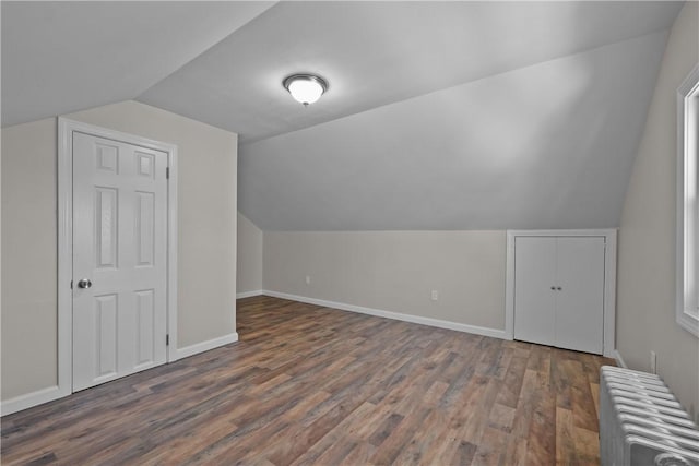 bonus room featuring lofted ceiling, dark hardwood / wood-style floors, and radiator