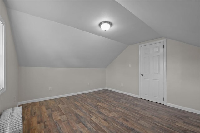 bonus room with dark hardwood / wood-style flooring and vaulted ceiling