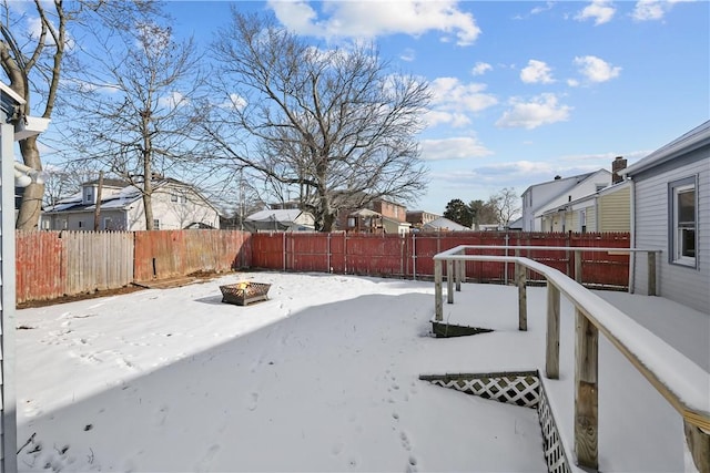 yard covered in snow with an outdoor fire pit