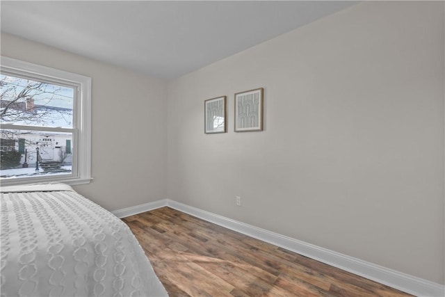 bedroom with dark hardwood / wood-style floors