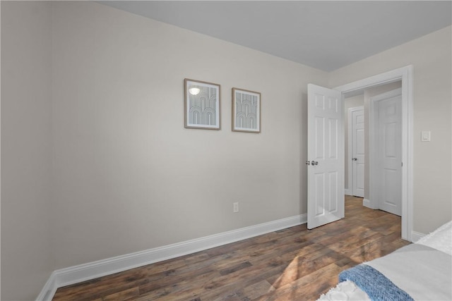 bedroom with dark hardwood / wood-style flooring