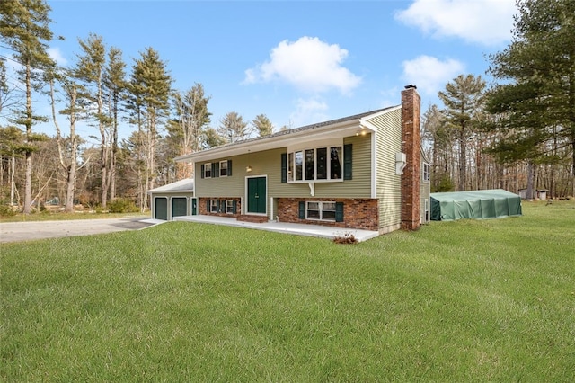 split foyer home featuring a garage and a front yard