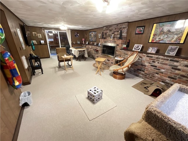 living room featuring a fireplace, light carpet, and wood walls