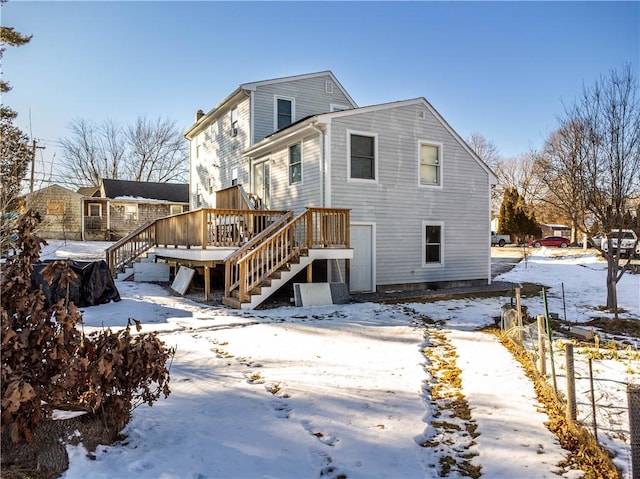 snow covered house featuring a deck