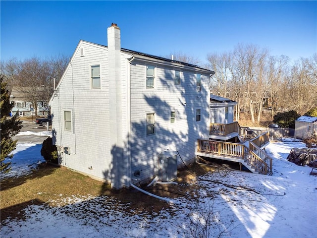 view of snowy exterior with a wooden deck