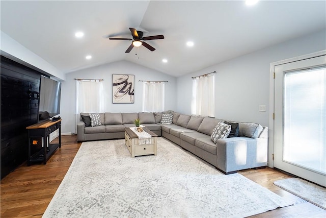 living room with hardwood / wood-style flooring, a wealth of natural light, ceiling fan, and vaulted ceiling