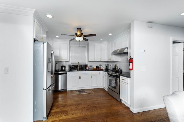 kitchen with appliances with stainless steel finishes, sink, white cabinets, and dark hardwood / wood-style floors