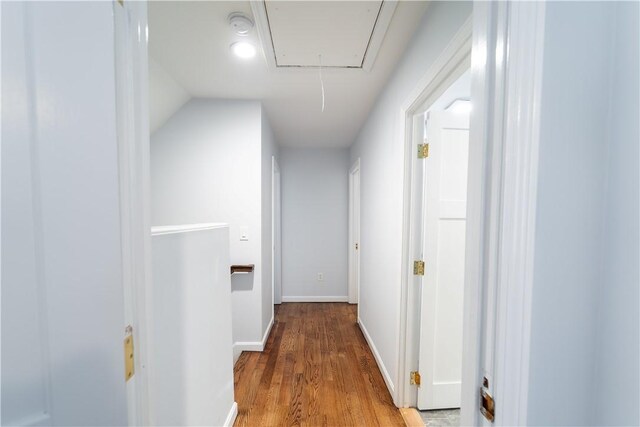 corridor featuring wood-type flooring and vaulted ceiling