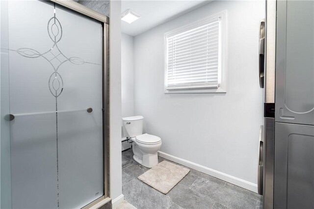 bathroom with a baseboard heating unit, an enclosed shower, and toilet