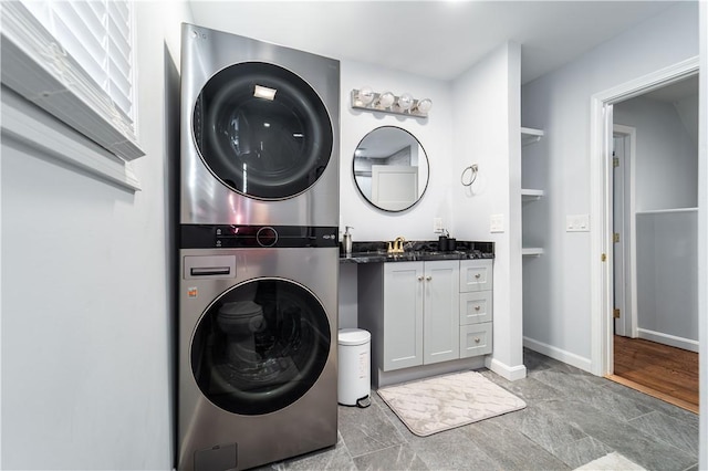 laundry room featuring stacked washer / drying machine and sink