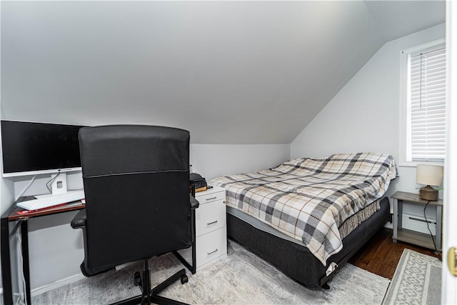 bedroom with lofted ceiling and light hardwood / wood-style floors