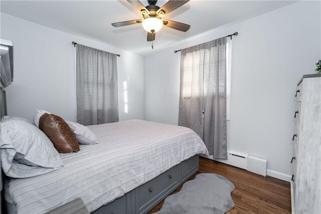 bedroom with a baseboard heating unit, dark hardwood / wood-style floors, and ceiling fan