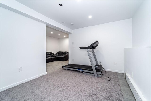 workout room featuring a baseboard radiator and carpet flooring