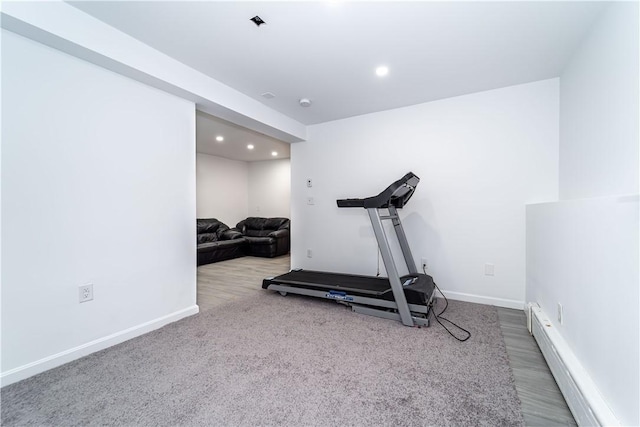 workout room featuring a baseboard heating unit and carpet flooring