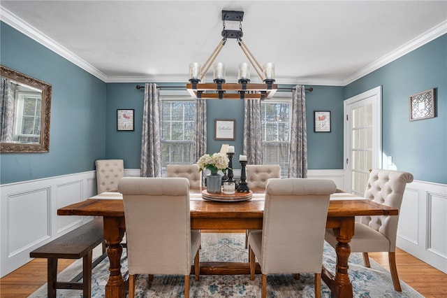 dining area with hardwood / wood-style floors, crown molding, and a chandelier