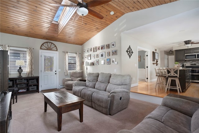 carpeted living room featuring ceiling fan, wooden ceiling, vaulted ceiling with skylight, and baseboard heating