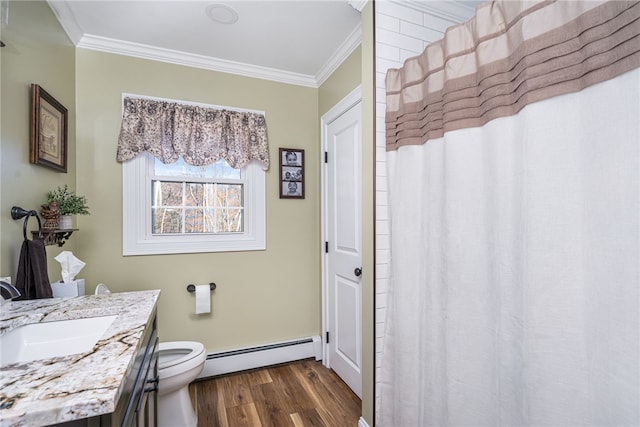 bathroom featuring ornamental molding, vanity, wood-type flooring, and a baseboard heating unit