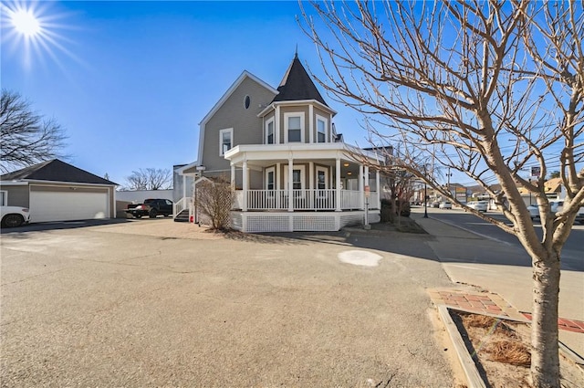 victorian home featuring a porch and a garage