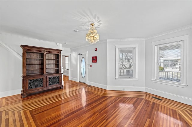 unfurnished living room featuring crown molding, wood-type flooring, and a chandelier