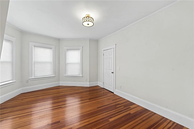 spare room with ornamental molding and dark hardwood / wood-style flooring