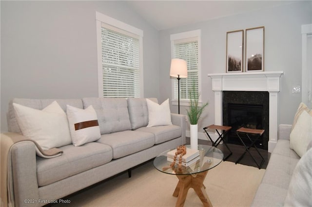 living room featuring a premium fireplace and lofted ceiling