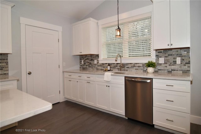 kitchen with vaulted ceiling, pendant lighting, tasteful backsplash, white cabinetry, and dishwasher