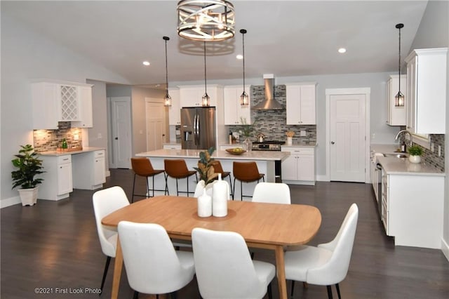 dining area with lofted ceiling, dark hardwood / wood-style floors, a chandelier, and sink