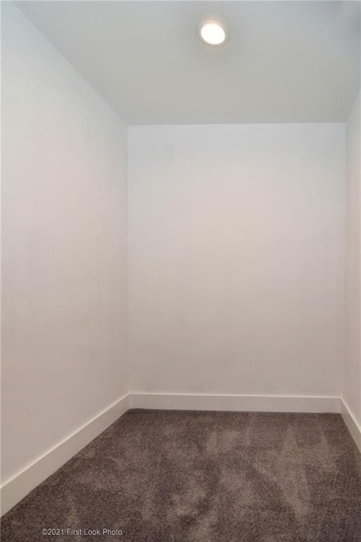 unfurnished room with dark colored carpet