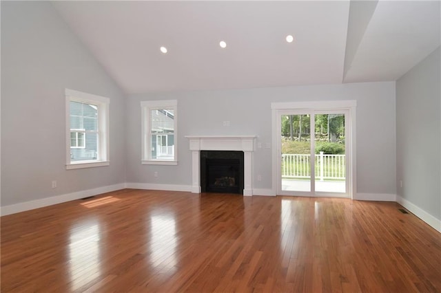 unfurnished living room with wood-type flooring and vaulted ceiling