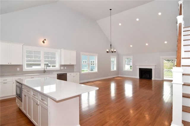 kitchen featuring white cabinetry, high vaulted ceiling, and a kitchen island