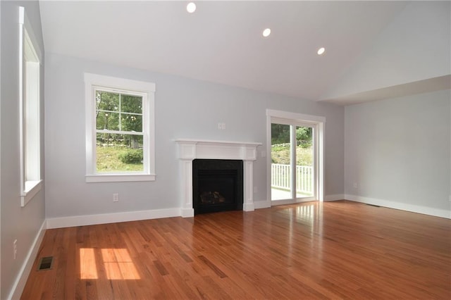 unfurnished living room featuring lofted ceiling and wood-type flooring