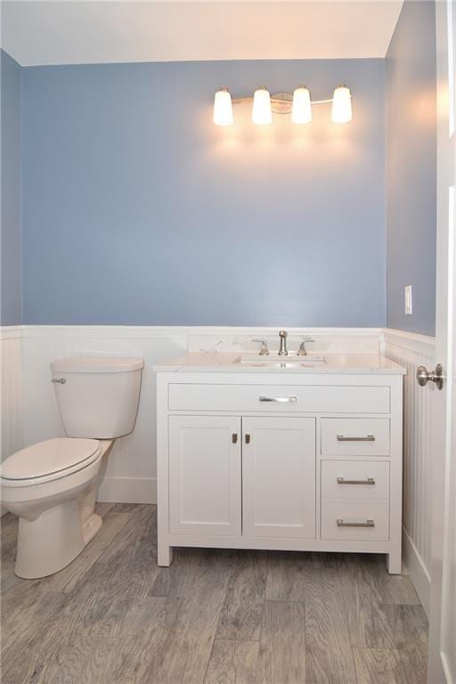 bathroom featuring hardwood / wood-style flooring, vanity, and toilet