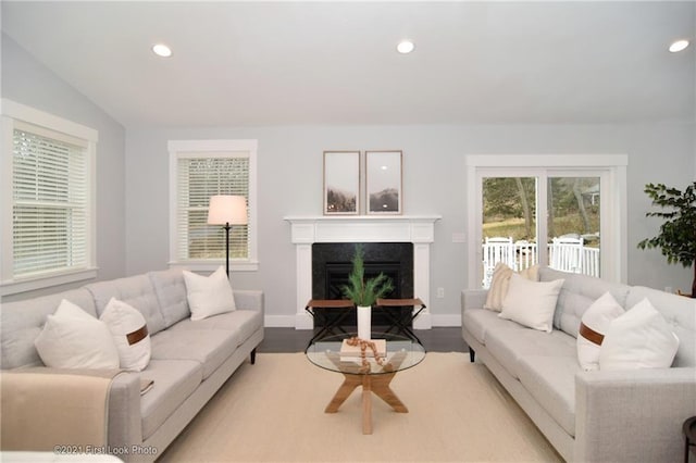 living room featuring lofted ceiling, a high end fireplace, and light hardwood / wood-style floors