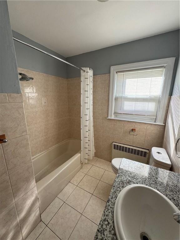 full bathroom featuring radiator, tile walls, tile patterned floors, toilet, and shower / bath combo with shower curtain