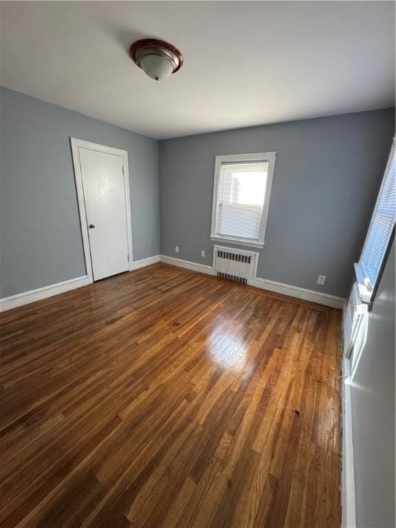 unfurnished room with radiator and dark hardwood / wood-style flooring