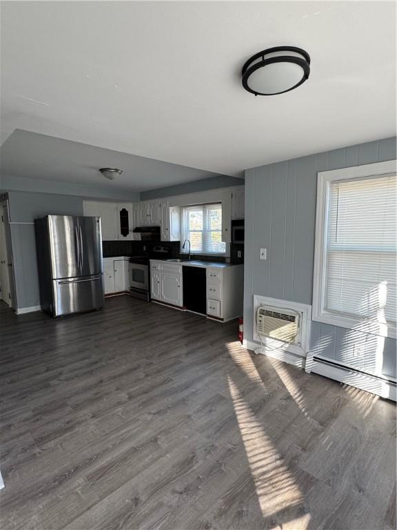 kitchen with sink, white cabinetry, appliances with stainless steel finishes, dark hardwood / wood-style flooring, and a wall unit AC