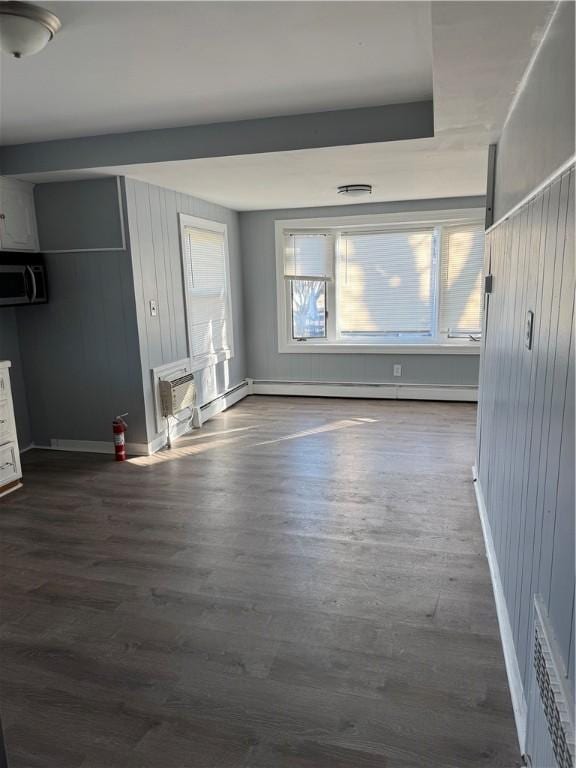 interior space with plenty of natural light, dark hardwood / wood-style floors, and a wall mounted AC