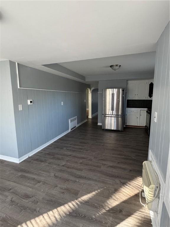 interior space with a wall mounted air conditioner, dark hardwood / wood-style floors, and a raised ceiling