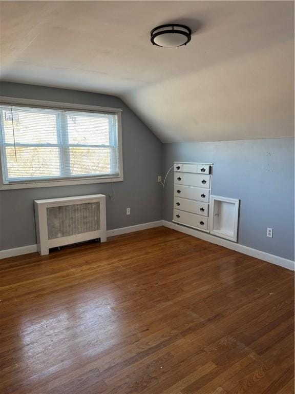 bonus room with hardwood / wood-style flooring, lofted ceiling, and radiator