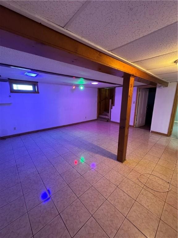 basement with a paneled ceiling