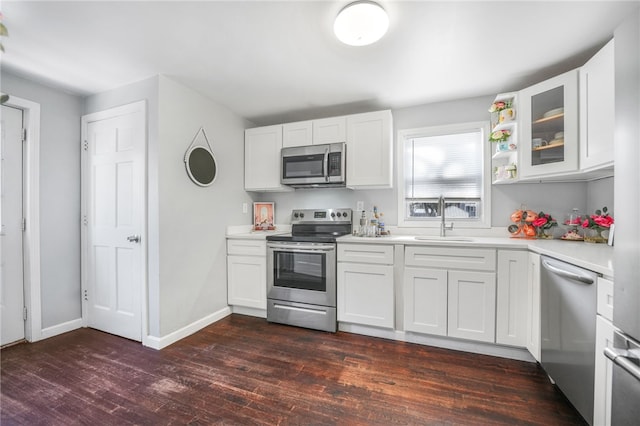 kitchen with sink, dark hardwood / wood-style floors, white cabinets, and appliances with stainless steel finishes