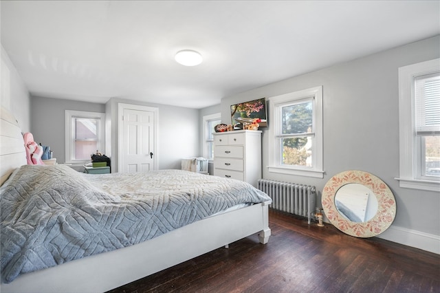 bedroom with multiple windows, radiator heating unit, and wood-type flooring