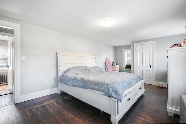 bedroom with dark wood-type flooring and radiator