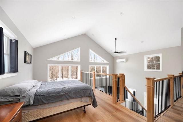 bedroom featuring lofted ceiling, a wall mounted air conditioner, and wood-type flooring