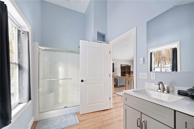 bathroom with lofted ceiling, an enclosed shower, hardwood / wood-style floors, and vanity