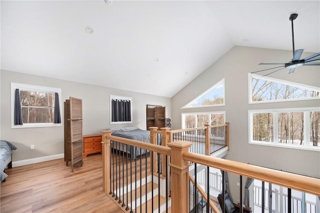 hall with lofted ceiling and light wood-type flooring