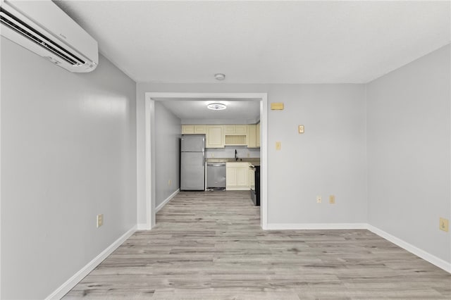 interior space featuring sink, light wood-type flooring, and an AC wall unit