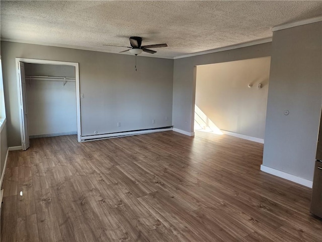 unfurnished bedroom featuring a baseboard heating unit, hardwood / wood-style floors, a textured ceiling, and ceiling fan