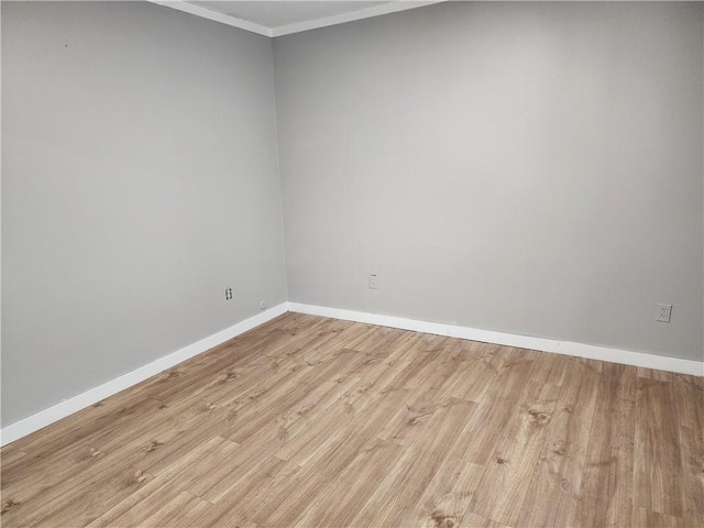 unfurnished room with ornamental molding and light wood-type flooring