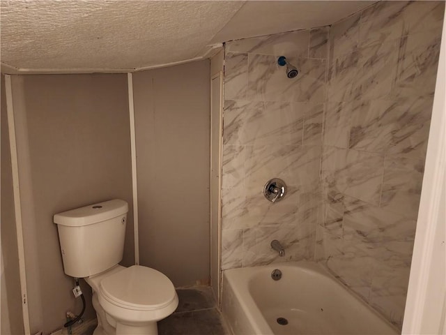 bathroom with tiled shower / bath combo, a textured ceiling, and toilet